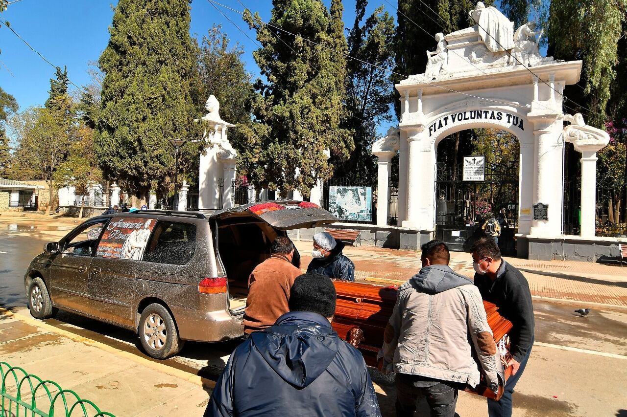 Los familiares retiran el féretro de un pariente de las puertas del cementerio de Cochabamba, donde no tienen cupo para enterrarlo.