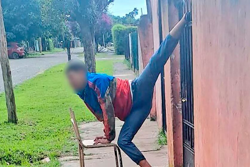 Los vecinos acercaron una silla al joven ladrón para que pueda adoptar una posición más cómoda mientras lo liberaban de la reja.