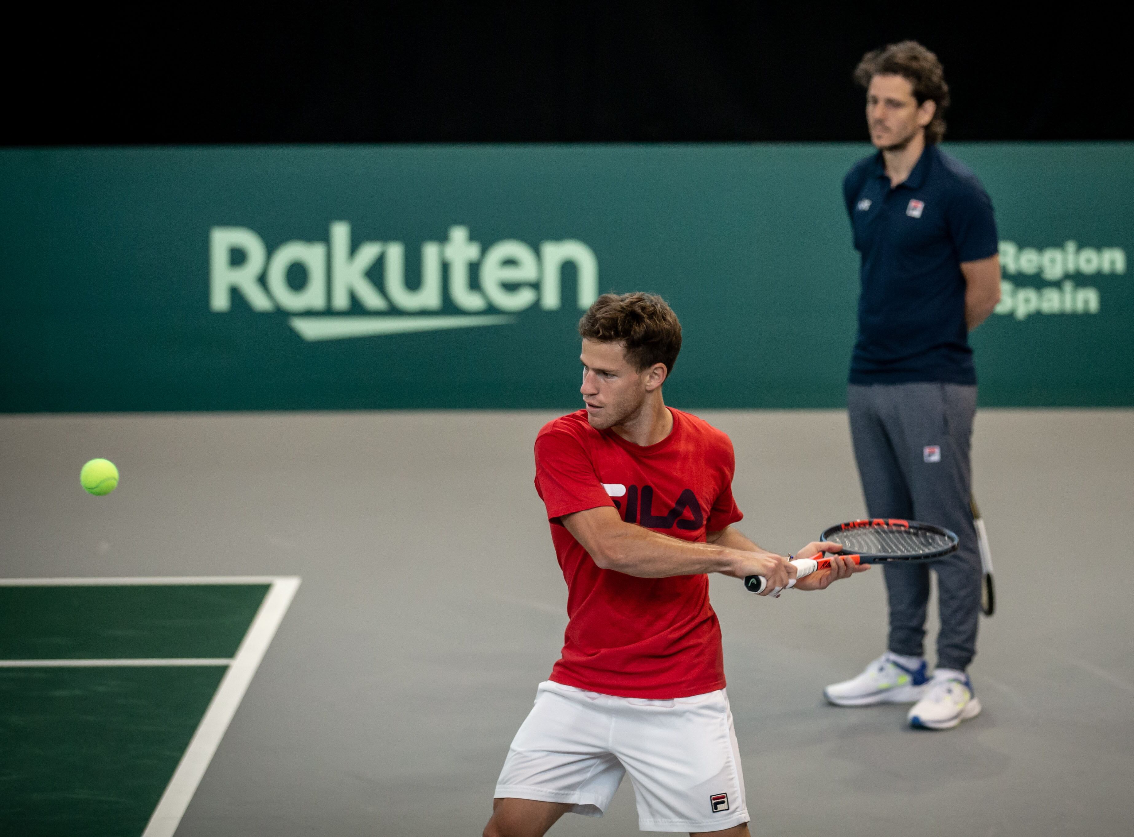 Schwartzman pega el revés, ante la atenta mirada del capitán Gaudio.