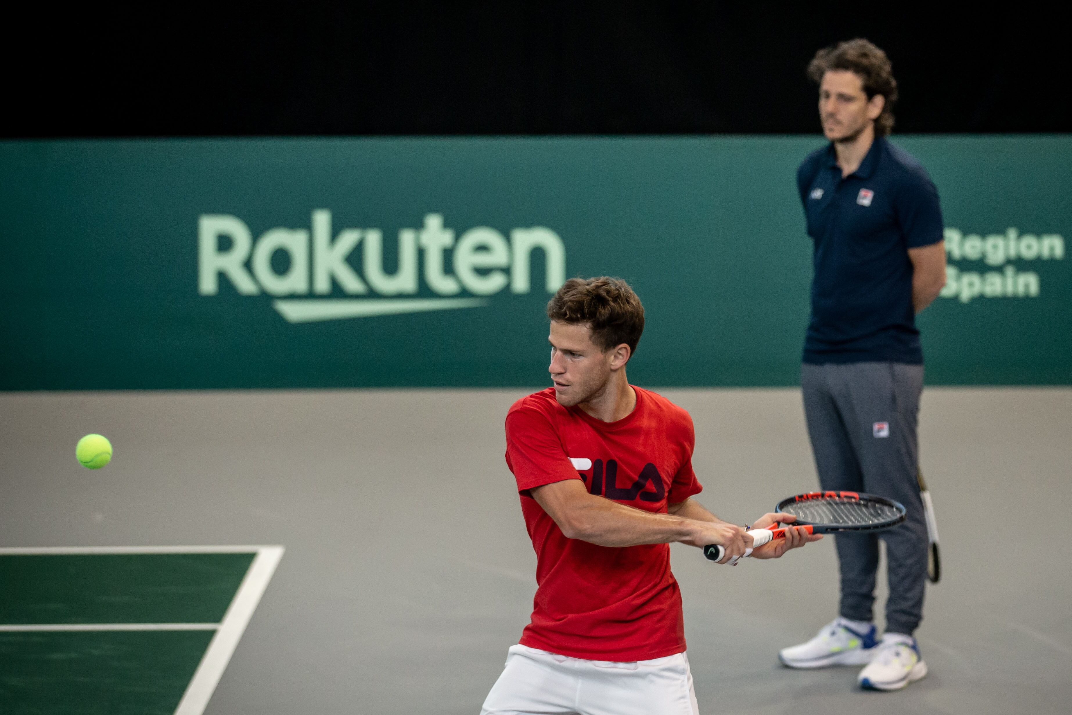 Schwartzman pega el revés, ante la atenta mirada del capitán Gaudio.
