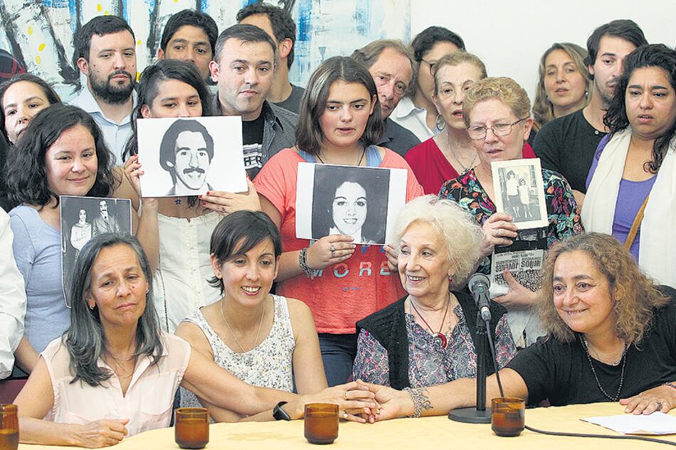 Adriana junto a Estela de Carlotto y sus tías Silvia y Marcela. Atrás, las fotos de sus padres.