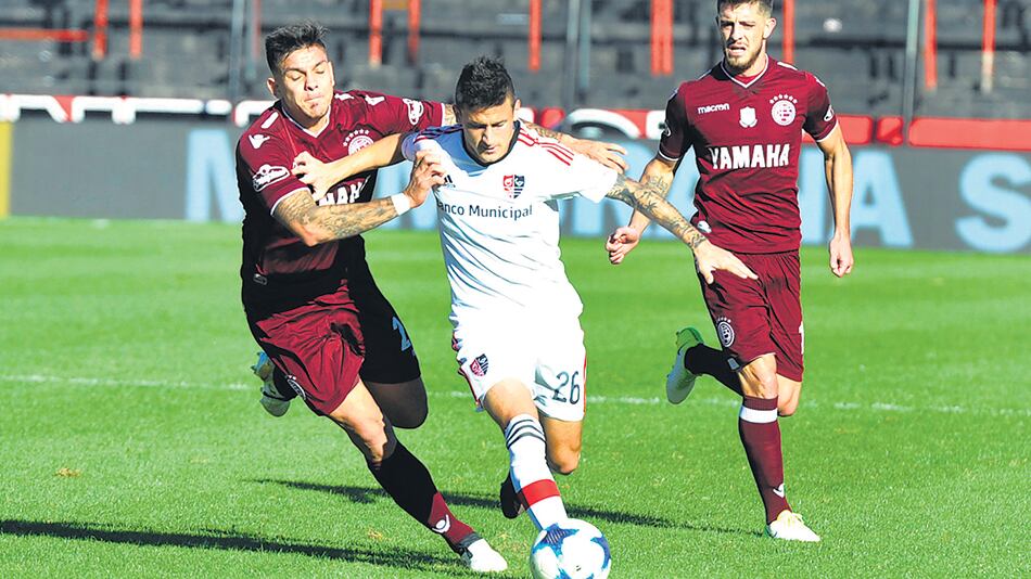 El joven Fértoli, autor del gol de los rosarinos, intenta escapar de la marca de Herrera, mientras Alejandro Silva observa un poco más atrás.