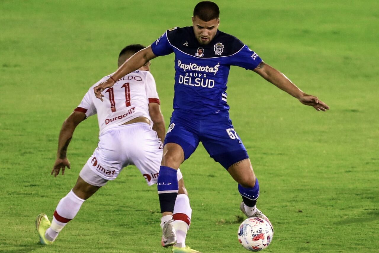 Weigandt se lleva la pelota ante Cristaldo. Huracán y Gimnasia quedaron a mano.