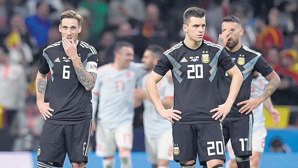 Biglia y Bustos tratan de encontrar respuestas ante la goleada de los españoles.