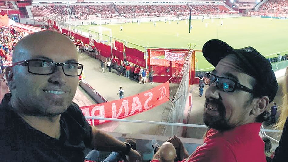 Francisco (con gorra) junto a su mejor amigo, Juan, en la platea del estadio.