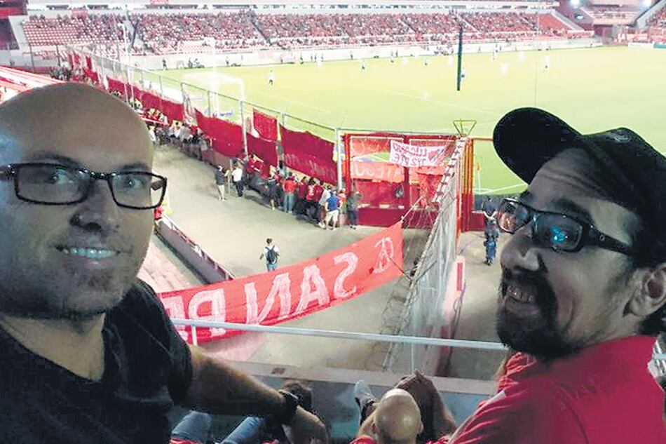 Francisco (con gorra) junto a su mejor amigo, Juan, en la platea del estadio.