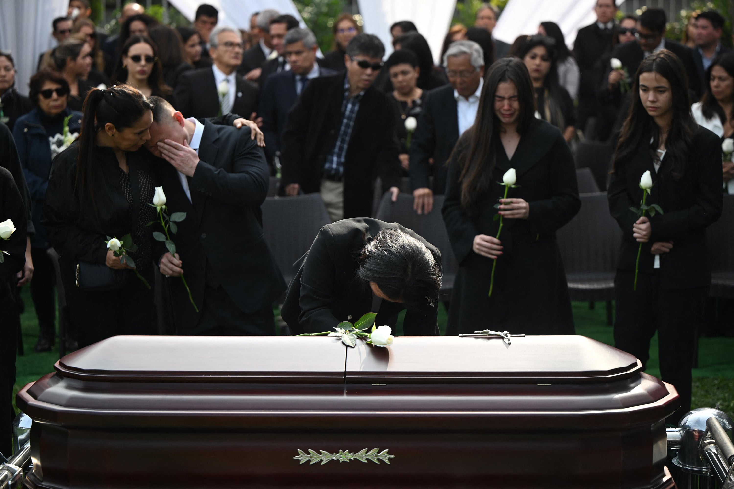 Keik Fujimori se inclina sobre el féretro de su padre durante el funeral del exdictador Fujimori.