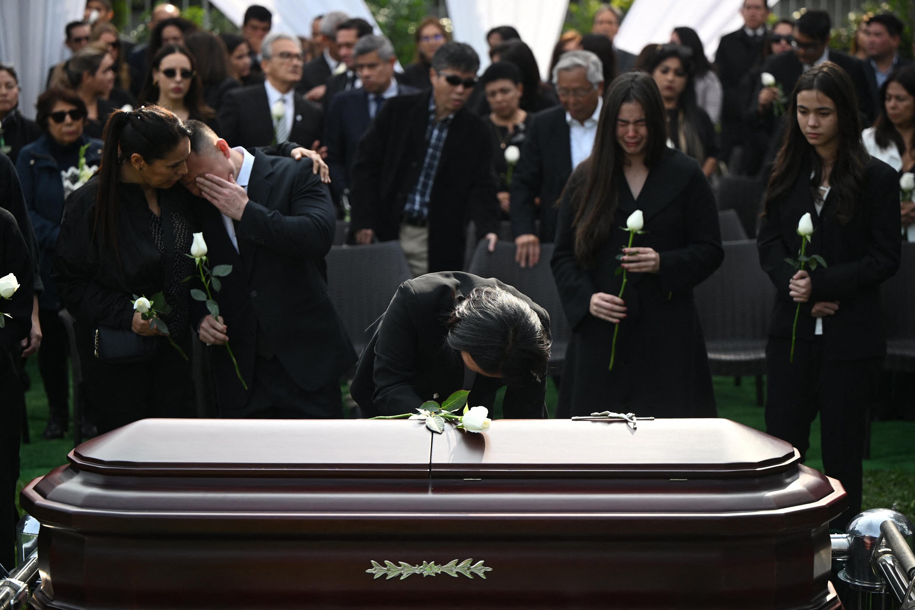 Keik Fujimori se inclina sobre el féretro de su padre durante el funeral del exdictador Fujimori.