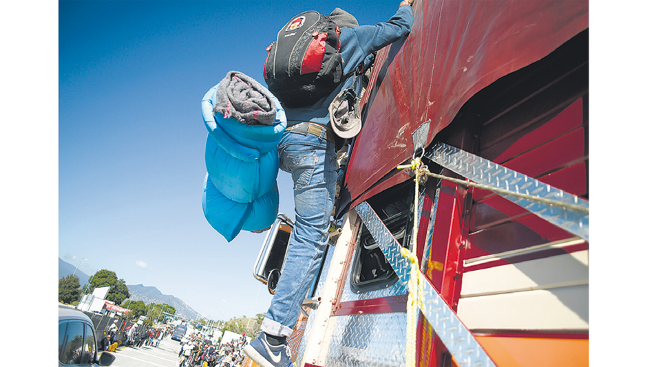 Un miembro de la caravana se sube a un camión en Jalisco.