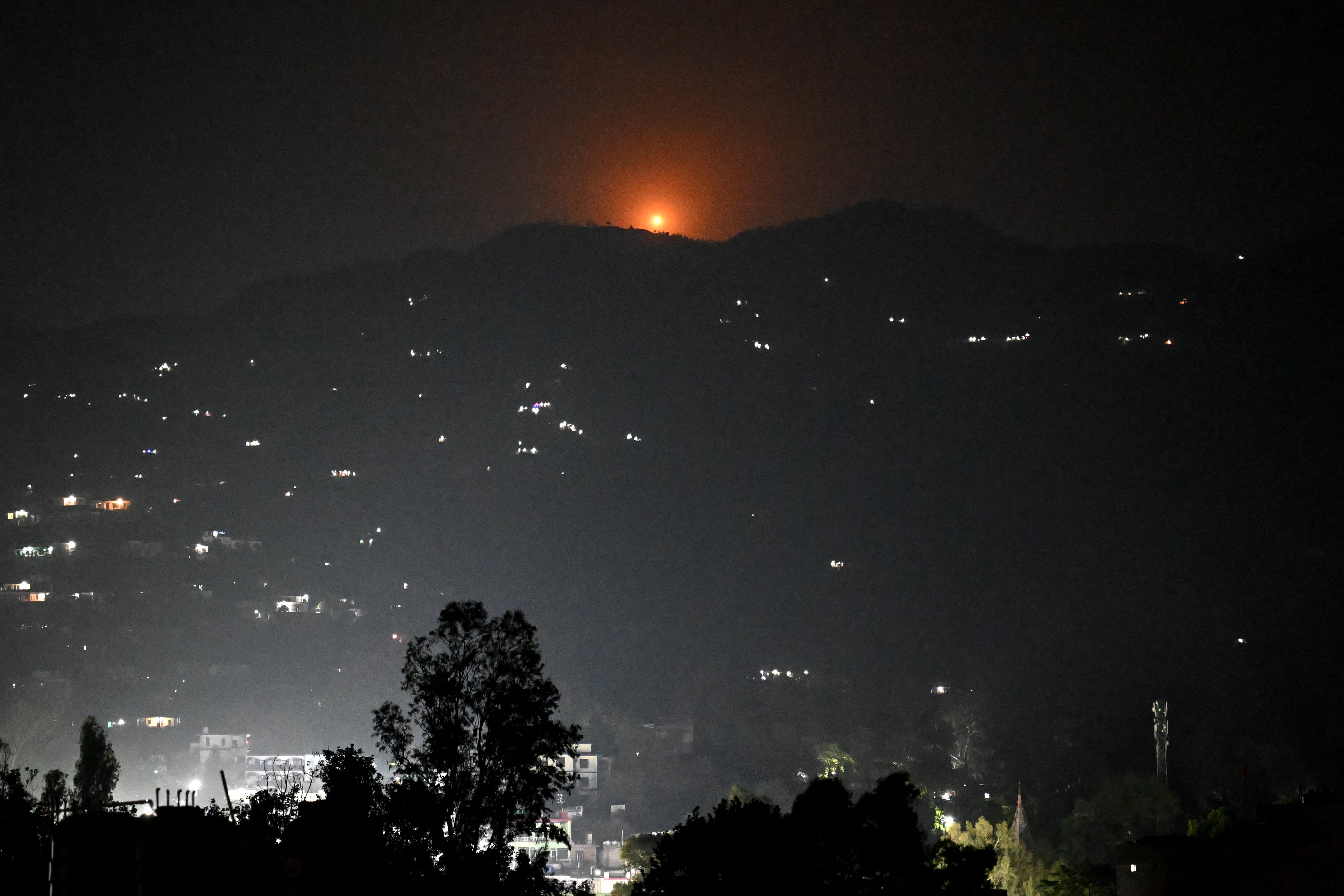 Una bengala se eleva sobre una colina cercana a la ciudad principal de Poonch