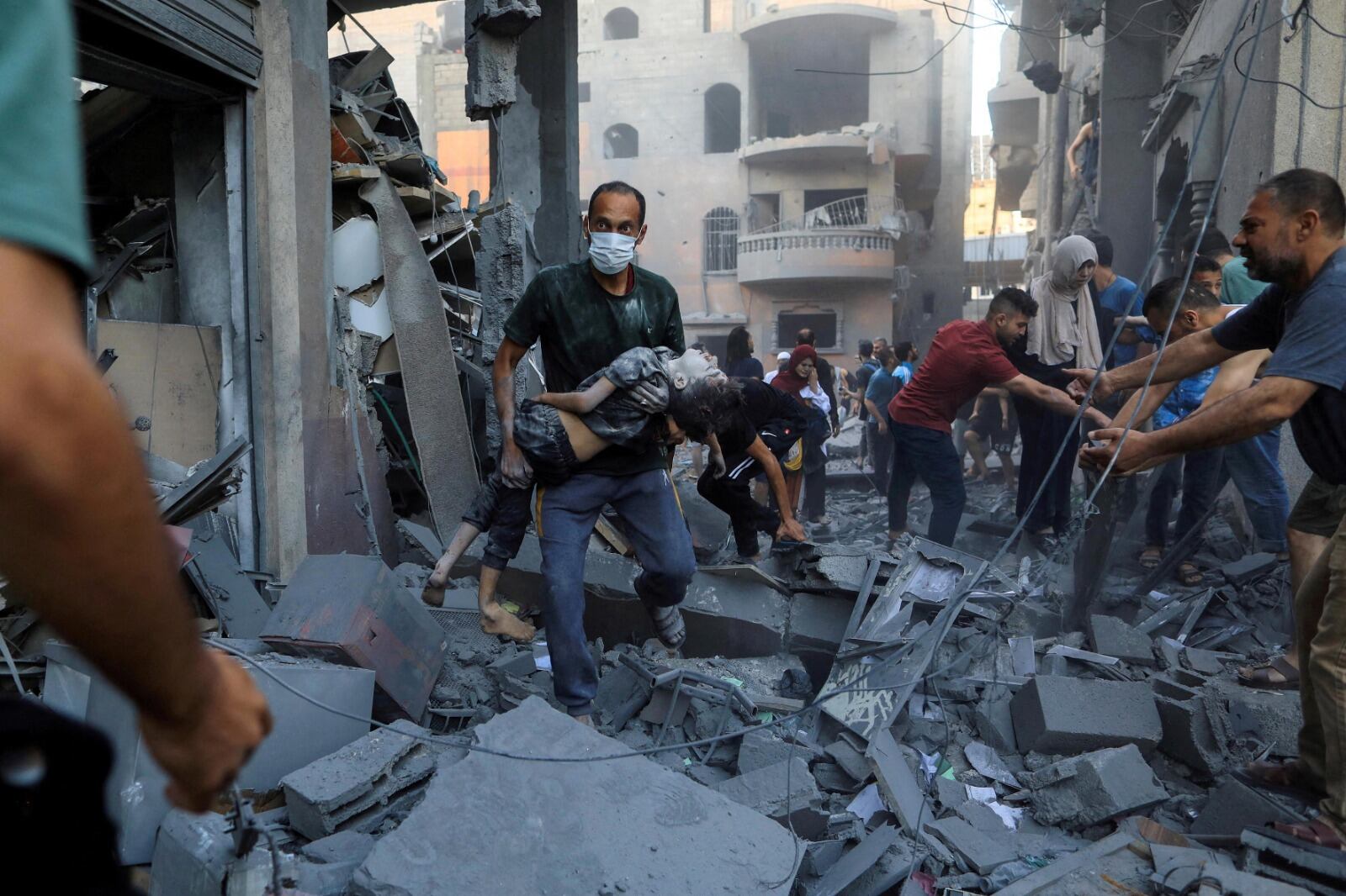  Un hombre carga a un 
niño herido en el lugar de un 
ataque israelí contra una casa 
en Khan Younis, Gaza.