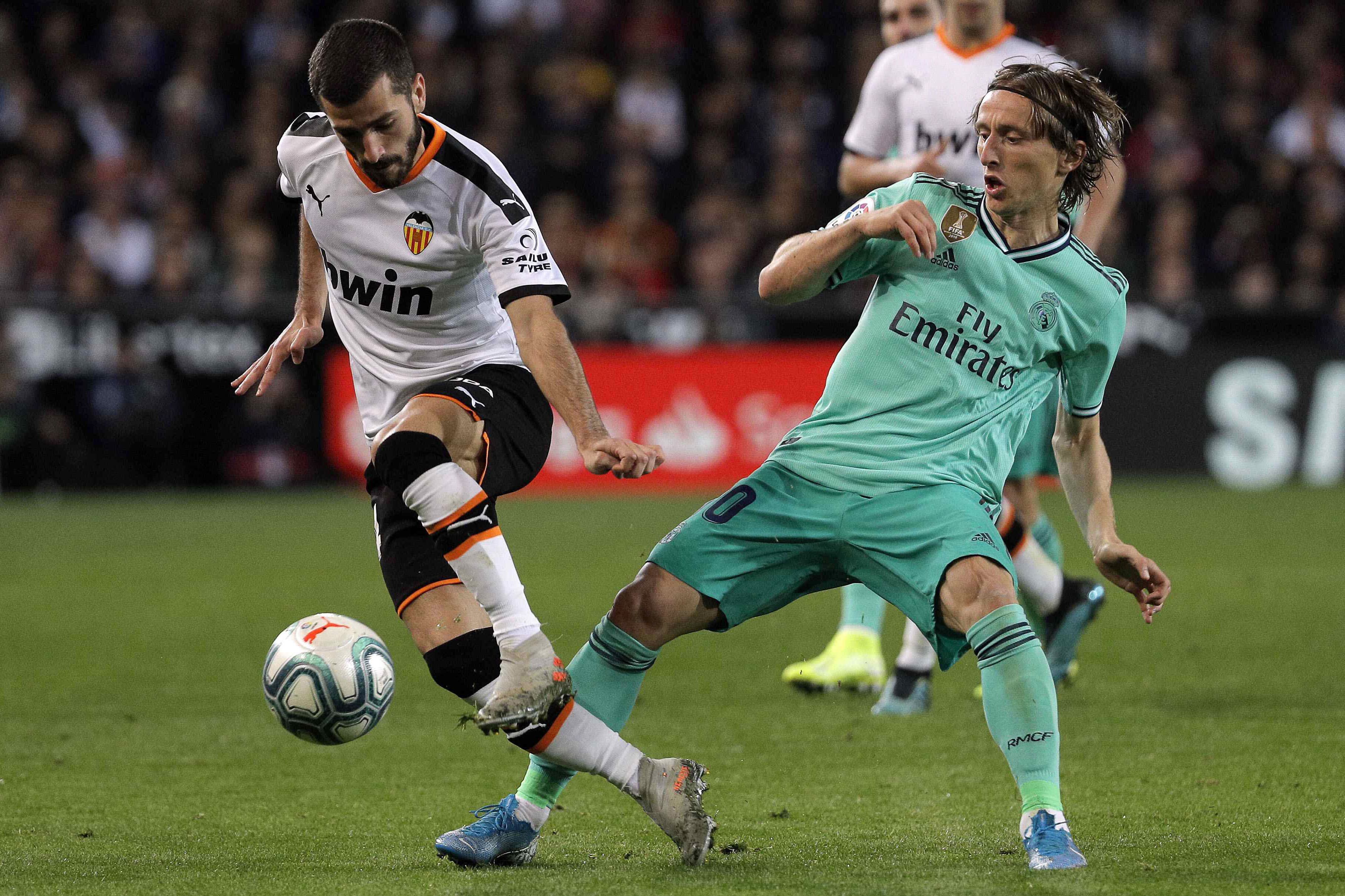 Soler y Modric disputan el balón en el medio del campo.