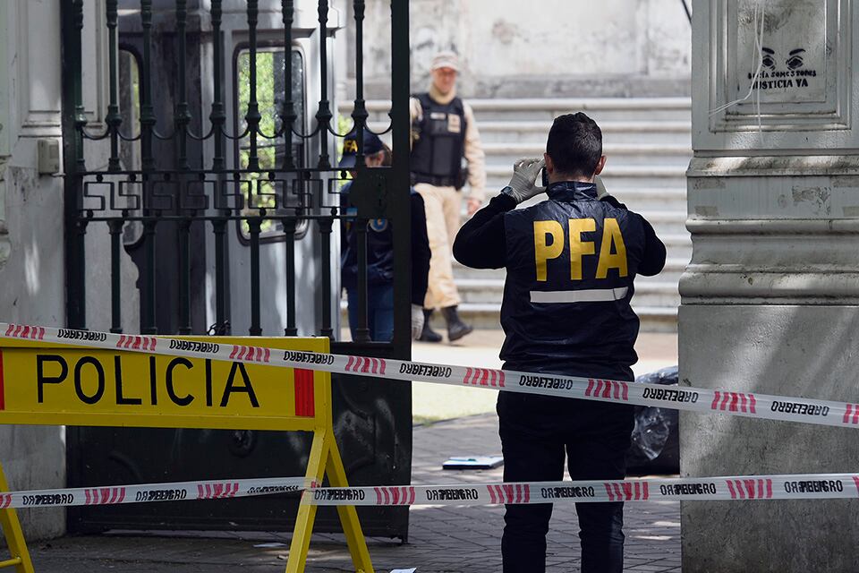 Policías relevan la escena del disparo, en el frente del edificio.
