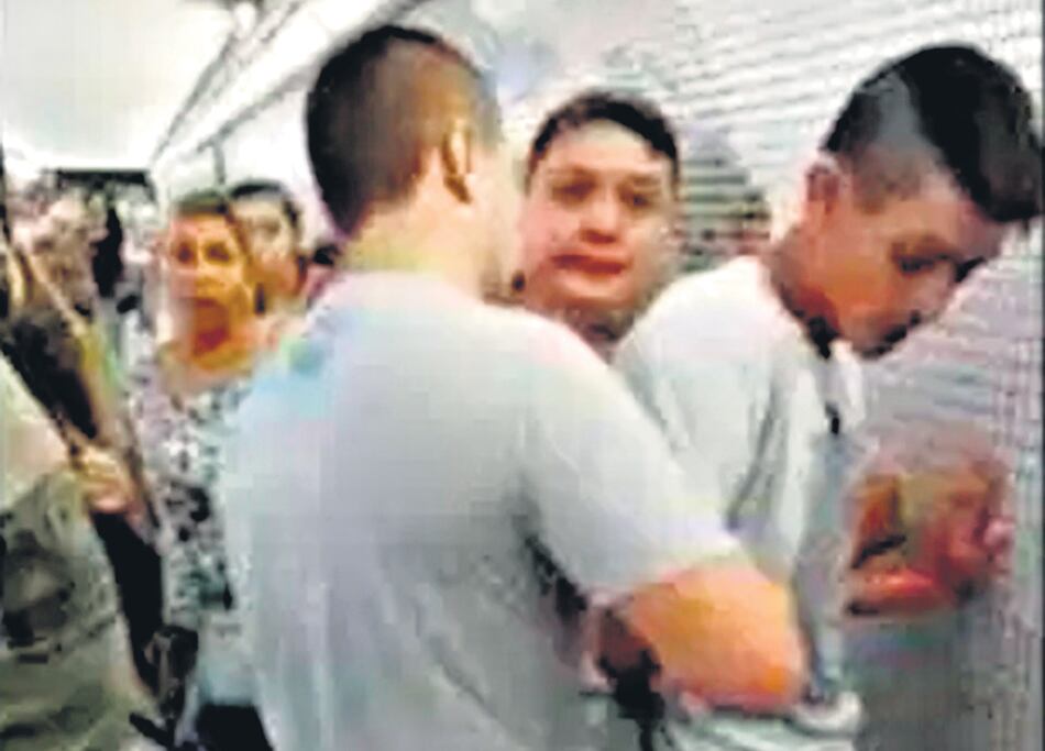 Dos de los tres gordos de la Policía de la Ciudad rodeados de pasajeros mientras detienen al vendedor.