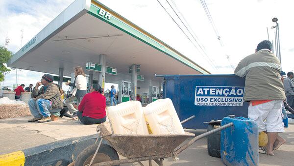 Grupos de personas intentan comprar nafta en una estación de servicio en Brasilia.