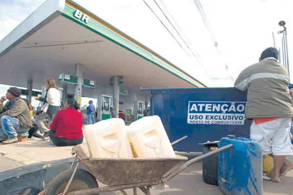 Grupos de personas intentan comprar nafta en una estación de servicio en Brasilia.