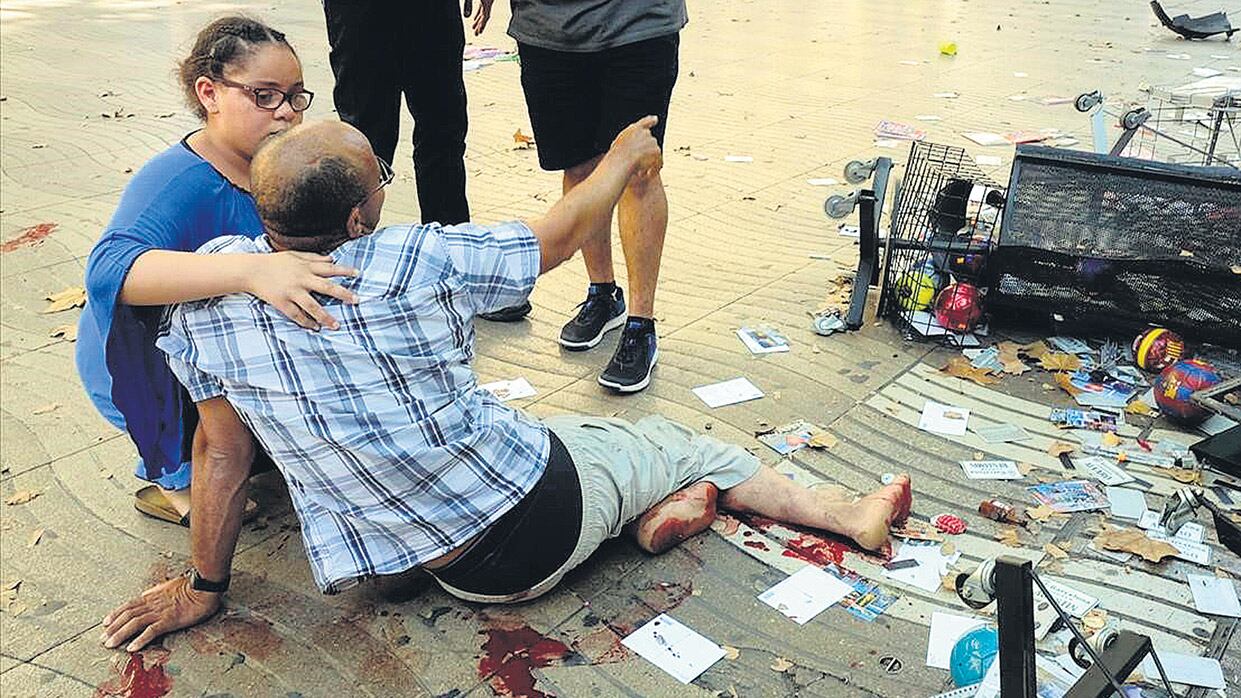 Una mujer asiste a un herido en La Rambla de Barcelona después del ataque reivindicado por el Estado Islámico.