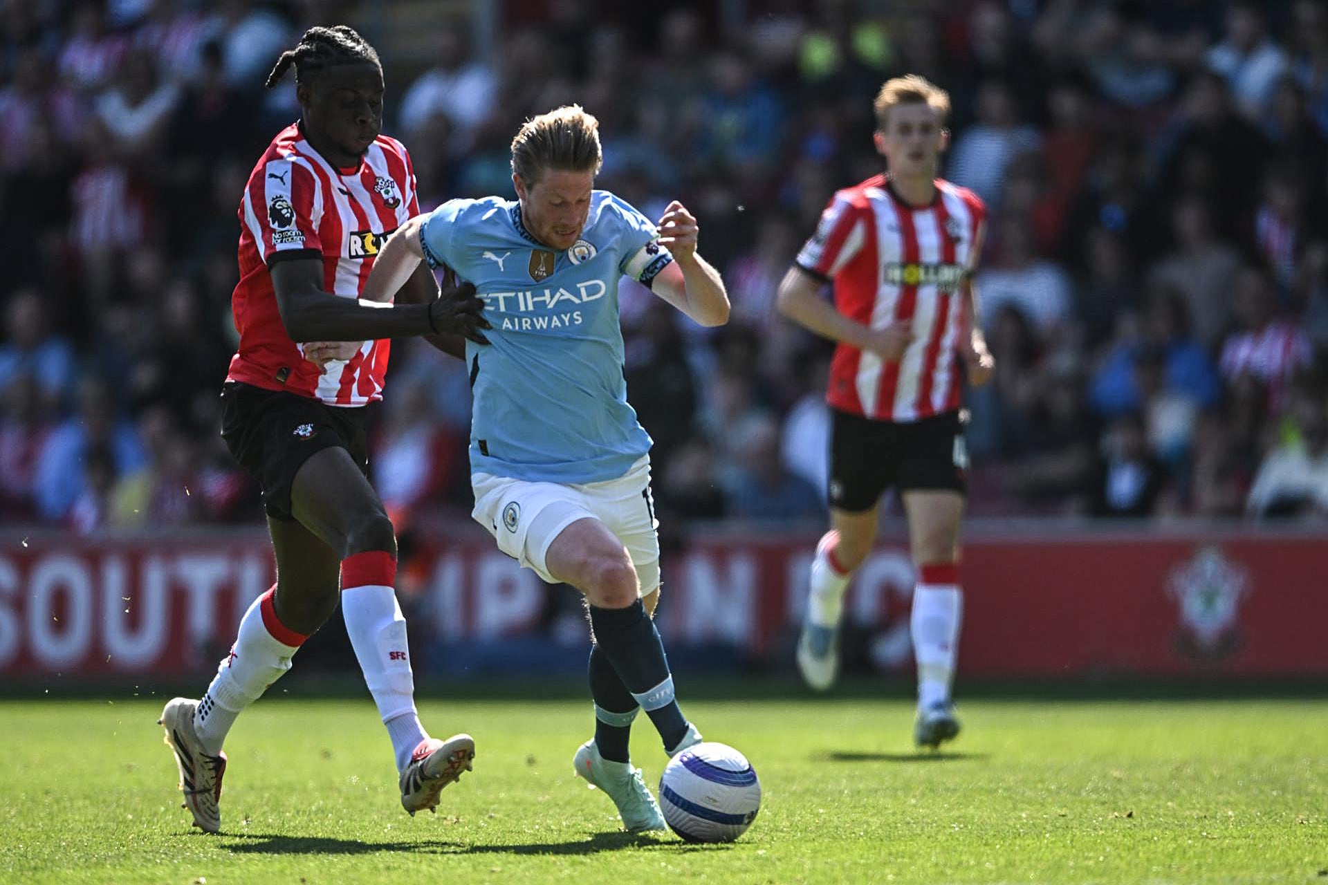 Kevin De Bruyne se lleva la pelota ante un rival