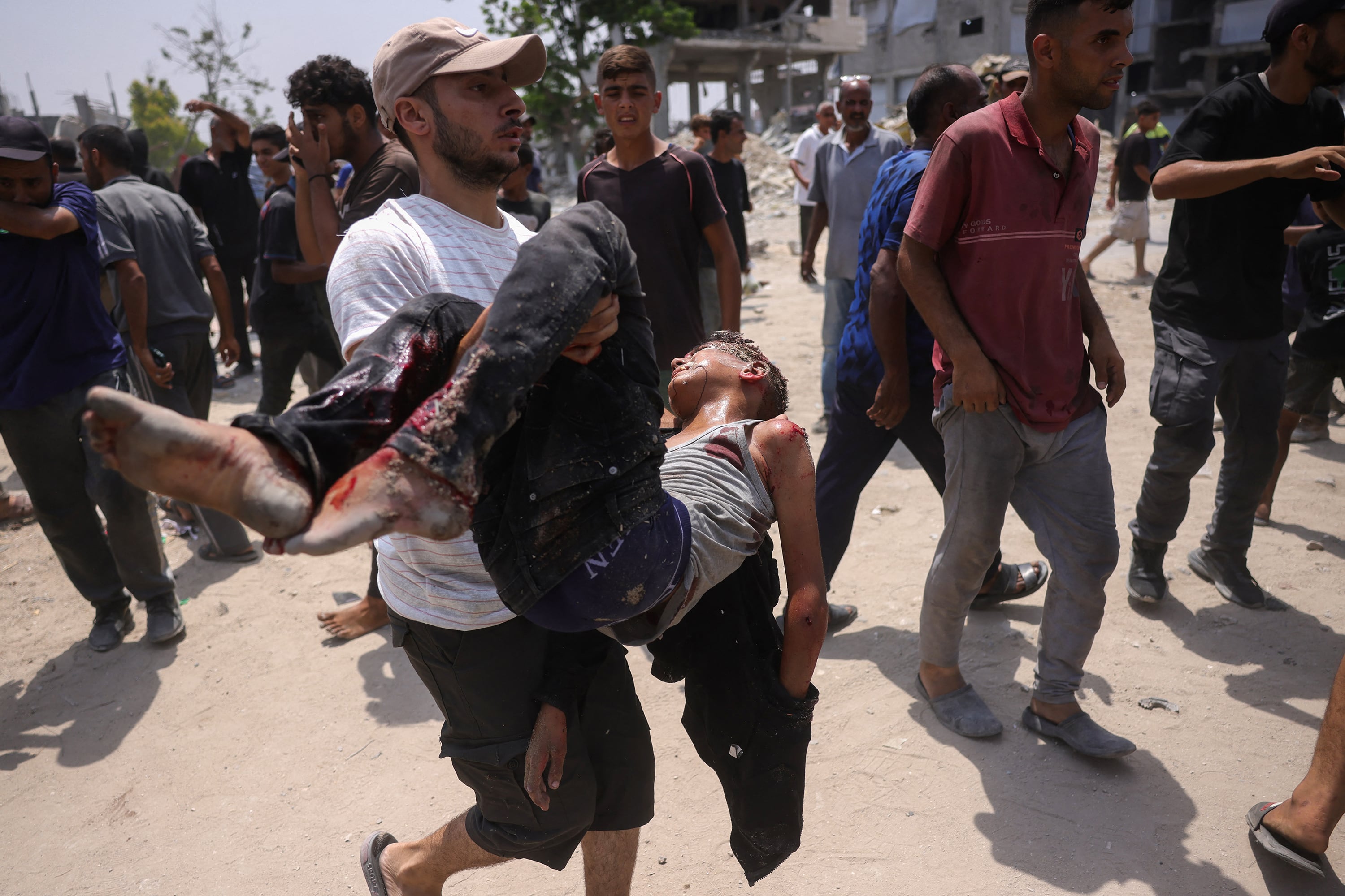 Un hombre carga en sus brazos a un joven herido tras nuevos ataques israelíes en el norte de Gaza