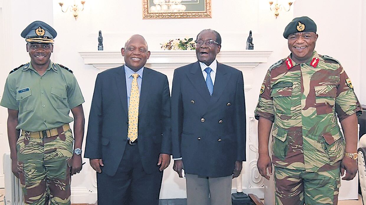 Mugabe (segundo a la der.) posa junto a los enviados sudafricanos.