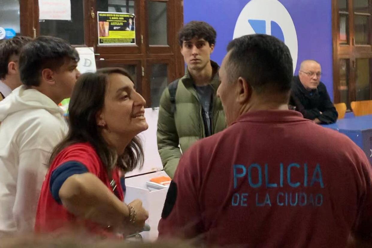 Uno de los efectivos, dialogando con una estudiante dentro de la Facultad de Derecho.