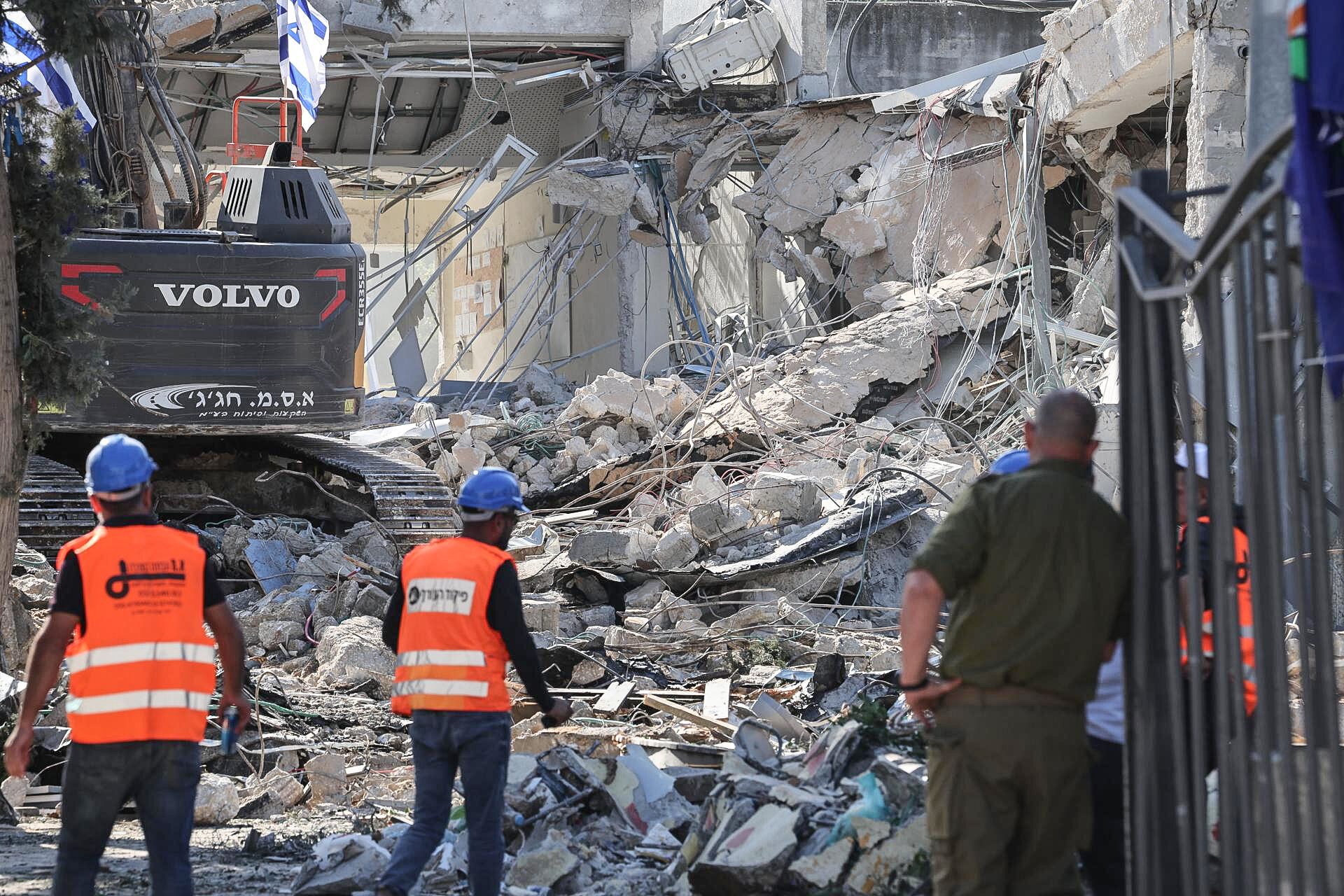 Trabajadores municipales examinan los escombros de un edificio destruido por un misil Yemení en Ramat Gan, centro de Israel.