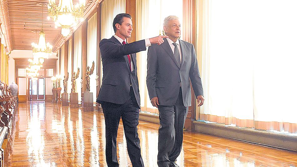 Peña Nieto y López Obrador recorren un pasillo del Palacio Presidencial durante su encuentro.