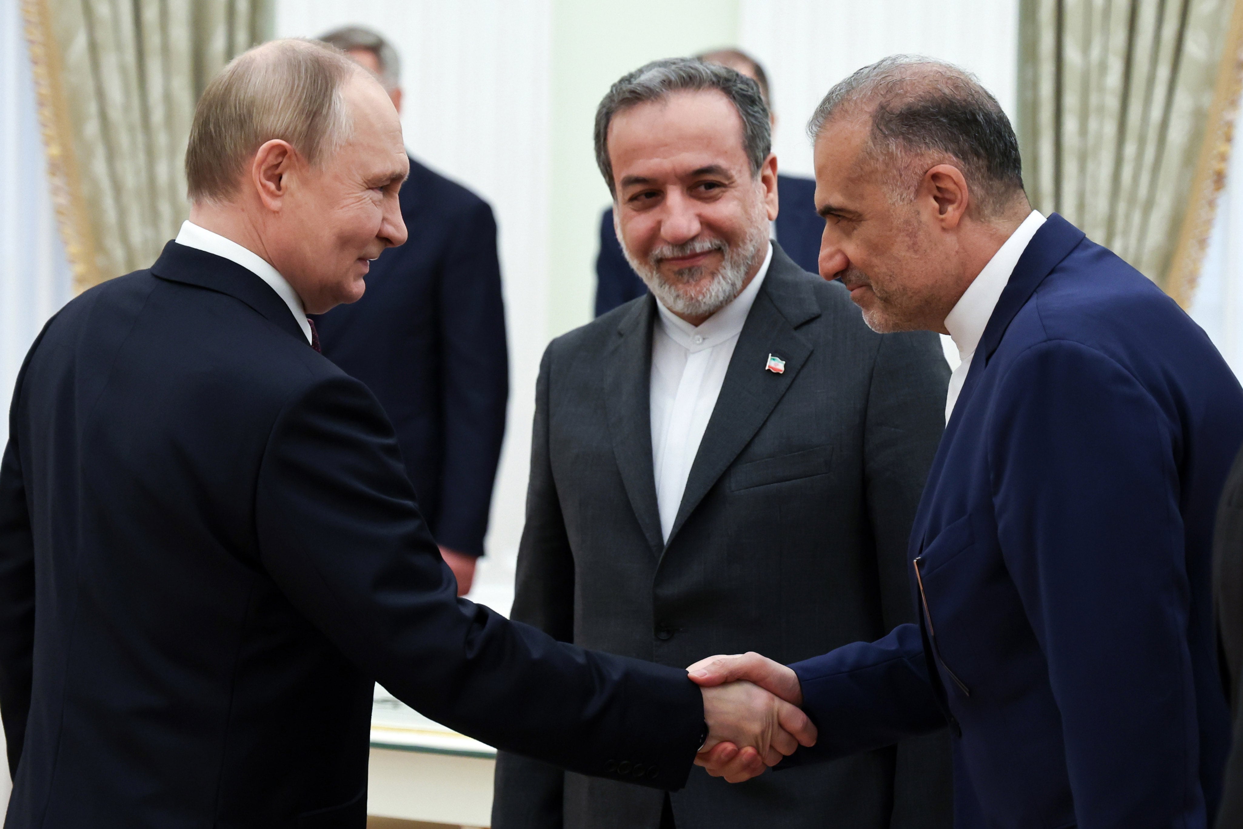 El presidente ruso, Vladimir Putin, estrecha la mano del embajador iraní en Rusia, Kazem Jalali, ante la mirada del canciller iraní, Abás Araqchí