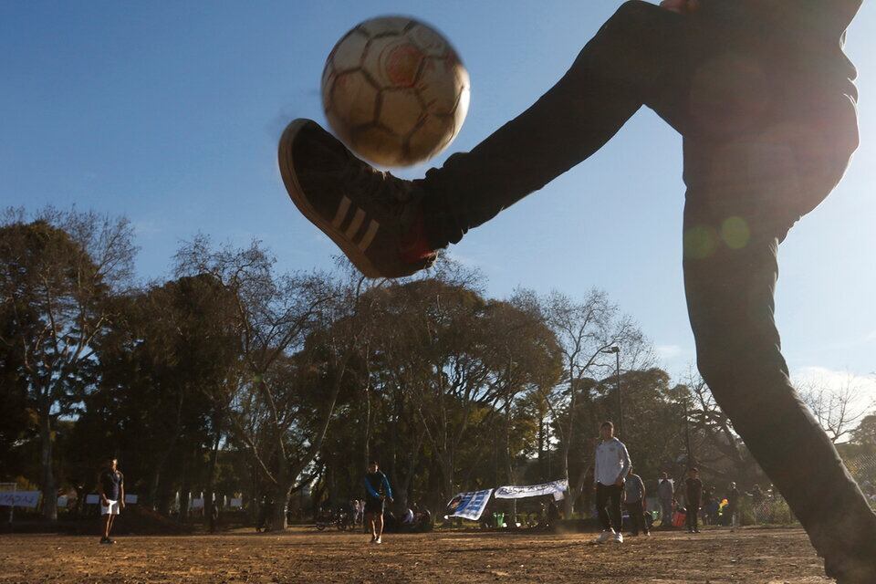 Chicos jugando al fútbol en un parque
