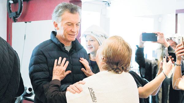 El presidente Mauricio Macri de visita en una peluquería porteña.