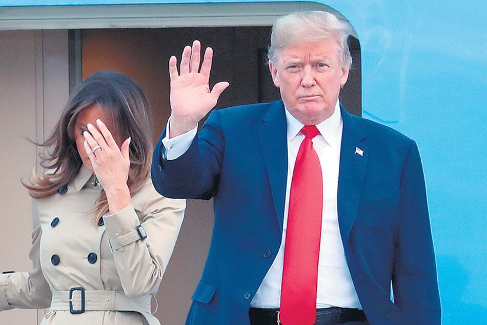 Trump, acompañado por Melania, saluda al llegar a Bruselas para asistir a la cumbre de la NATO.