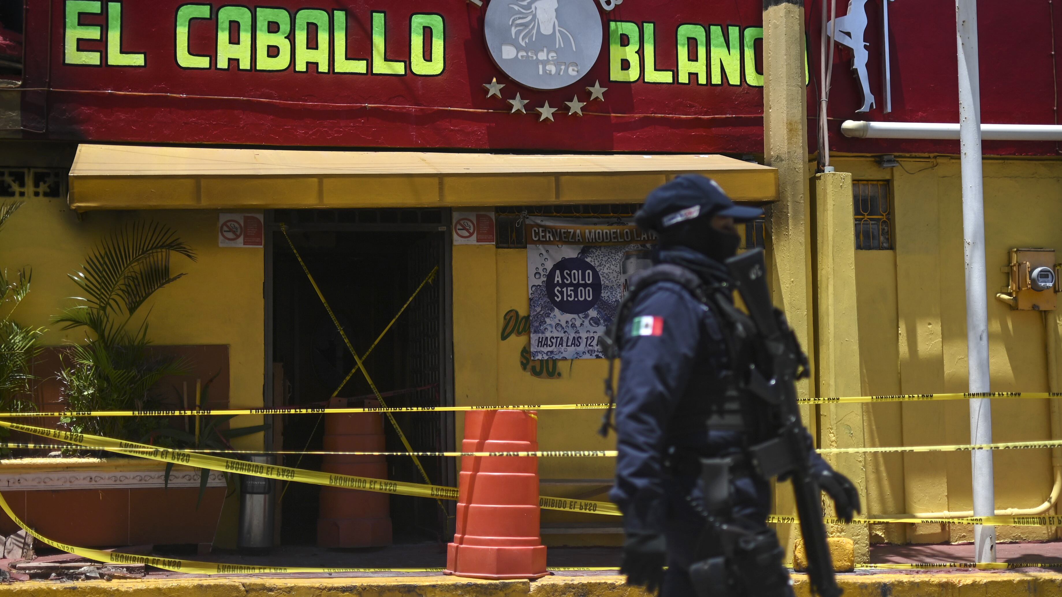 Un policía antimotines custodia el bar después de la masacre.