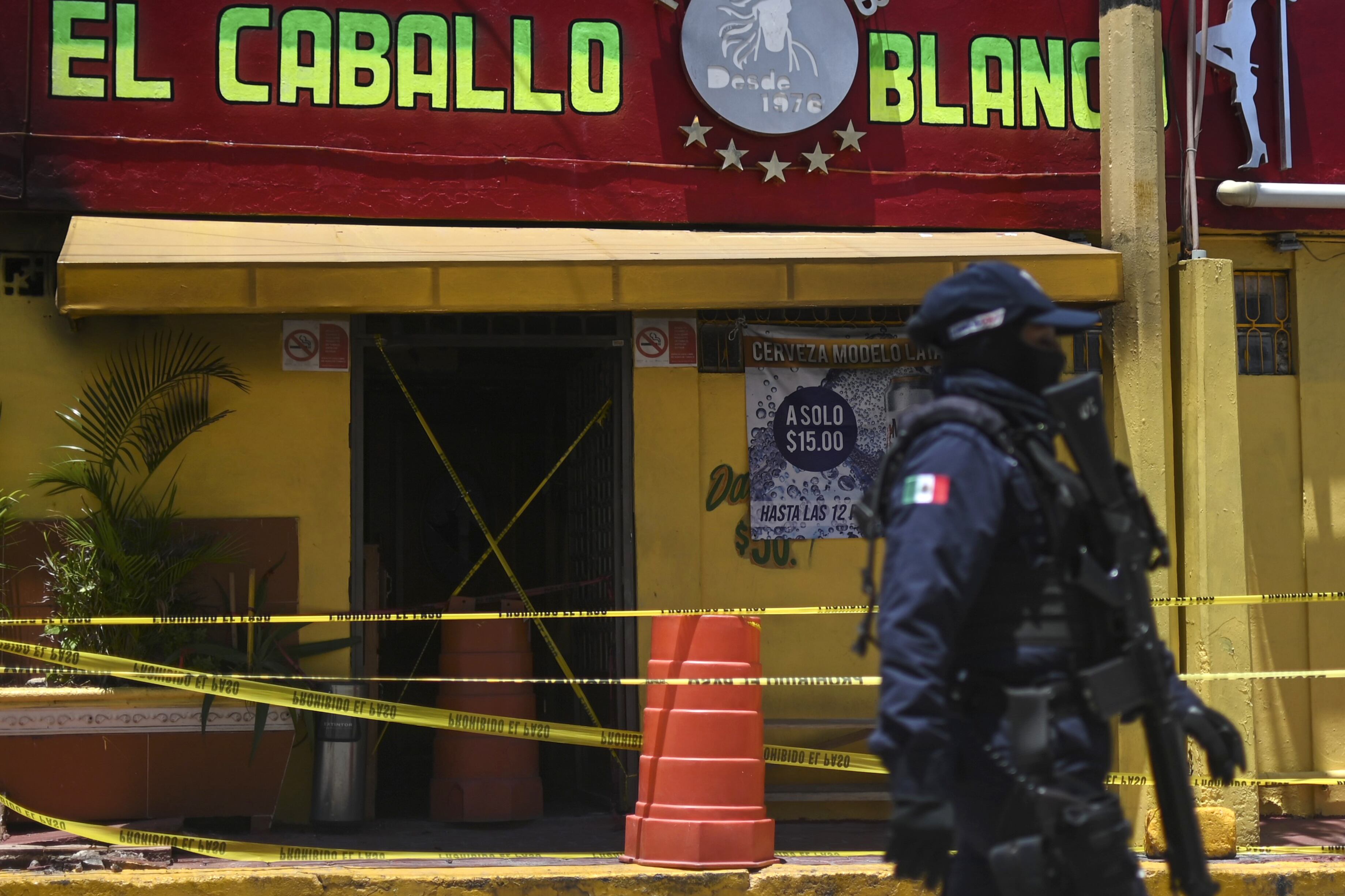 Un policía antimotines custodia el bar después de la masacre.