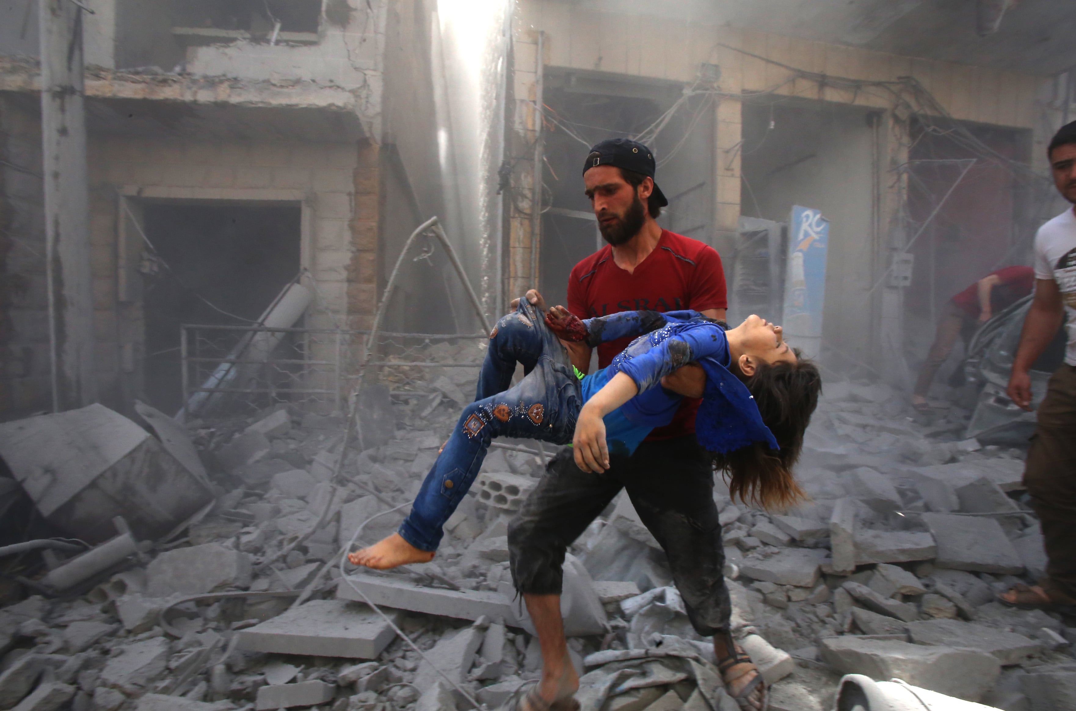 Un hombre evacúa a una víctima de un bombardeo en Maaret Al-Noman, provincia de Idlib.