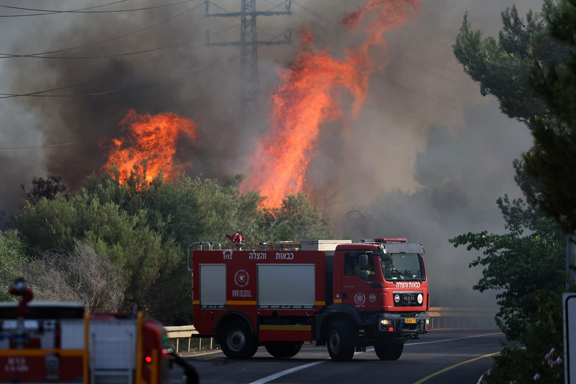 Bomberos israelíes apagan un incendio causado por un ataque de Hezbolá en Galilea.