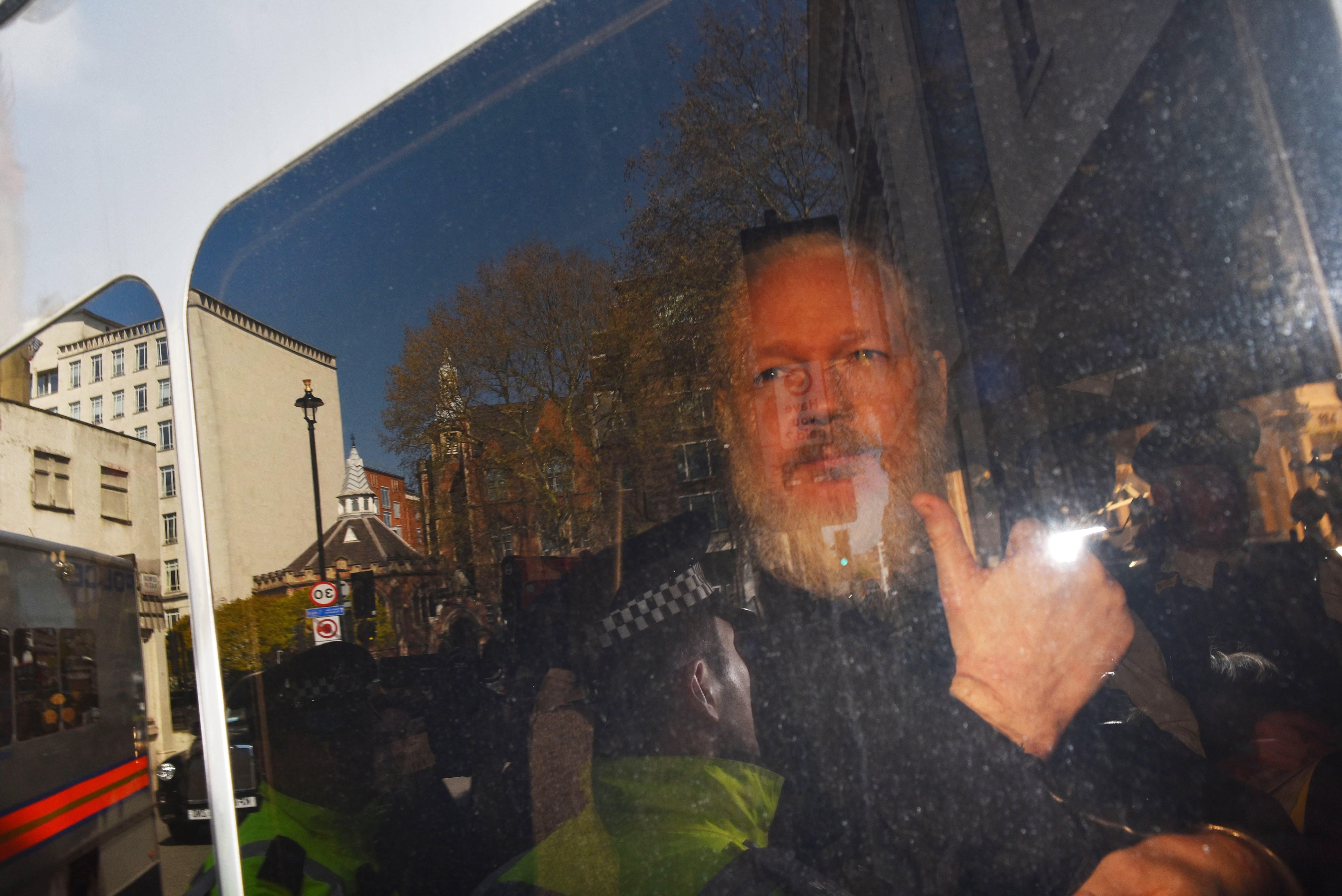 Assange es arrestado por policías británicos y subido a un patrullero frente a la embajada de Ecuador.