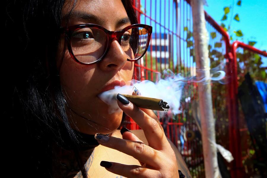 Una mujer fuma un cigarro de marihuana en el Zócalo de la Ciudad de México mientras la Cámara baja debatía la aprobación del cannabis para uso personal. 
