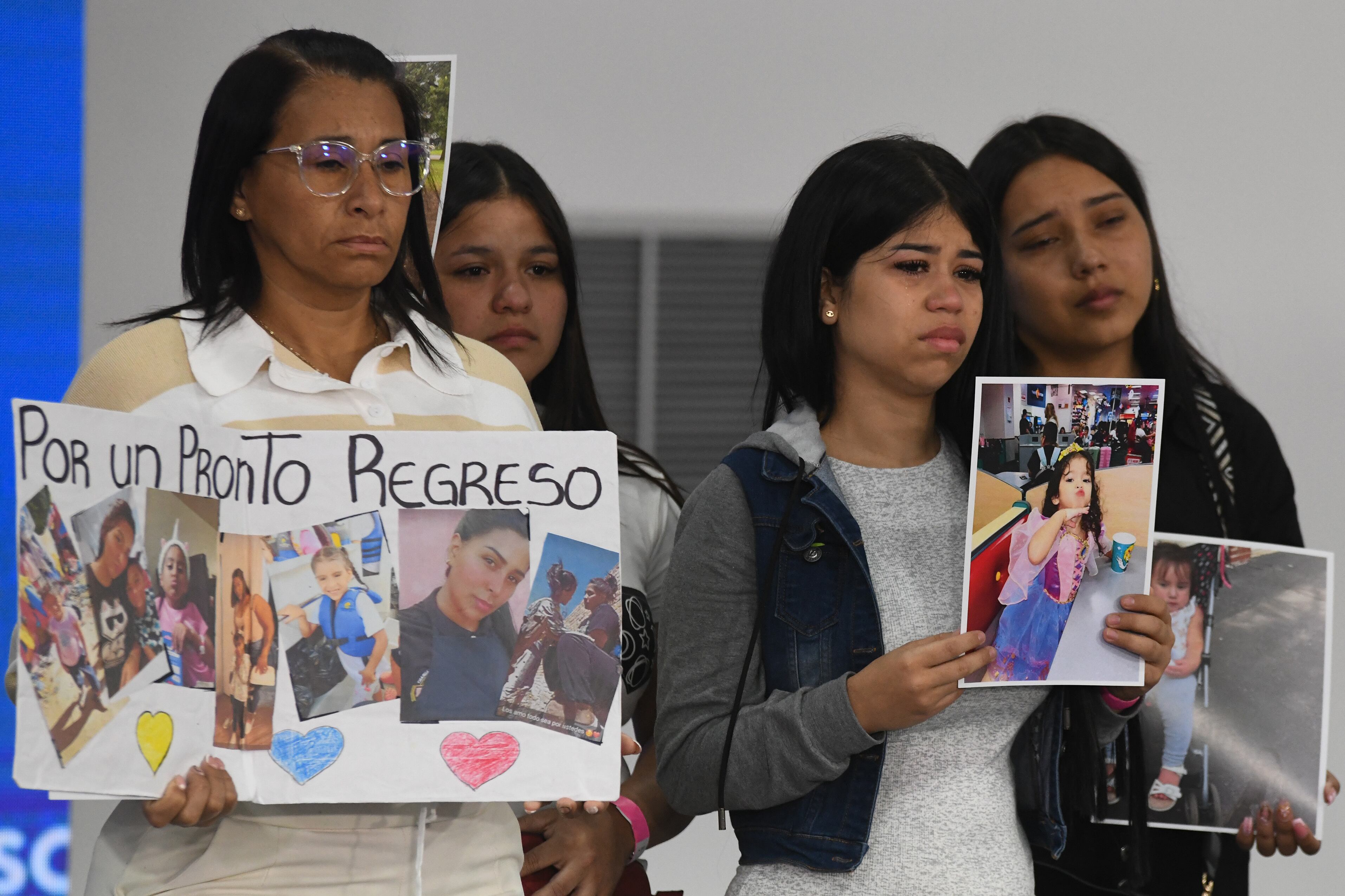Familiares de menores migrantes que permanecen en Estados Unidos sostienen fotografías durante una conferencia de prensa en Caracas.