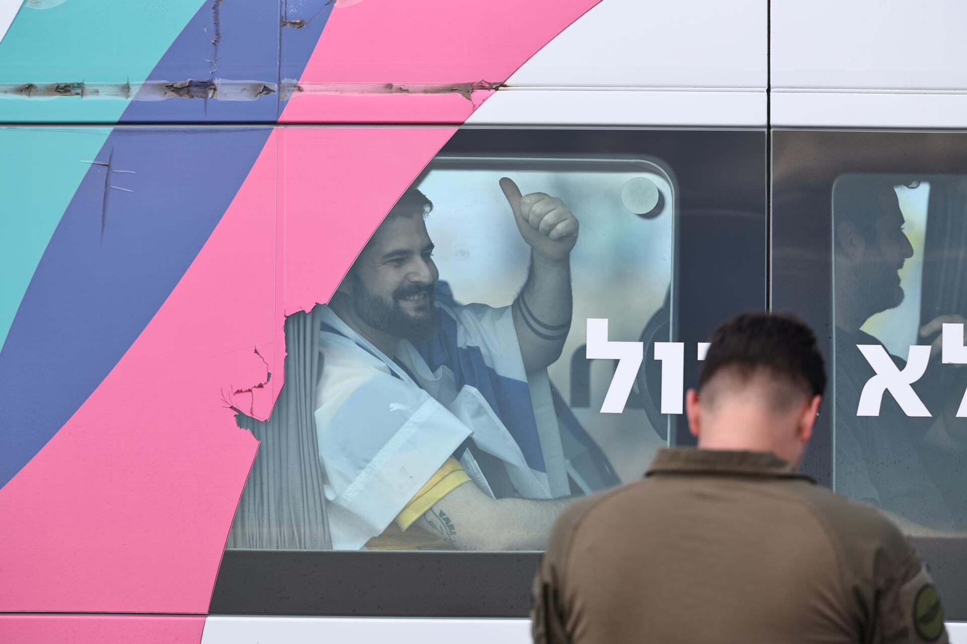 El liberado Ziv Berman saluda desde la ventana de su ambulancia al llegar al hospital Sheba en Ramat Gan.