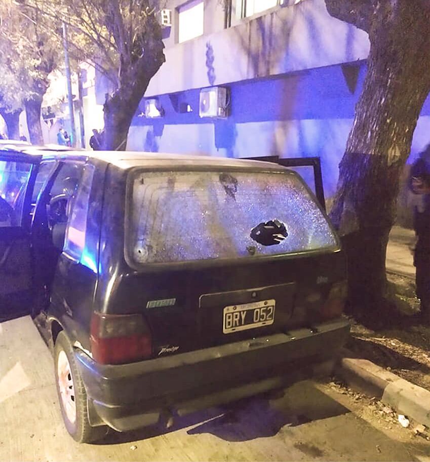 El Fiat Uno en el que viajaba la familia atacada por el policía, con un balazo en la luneta.