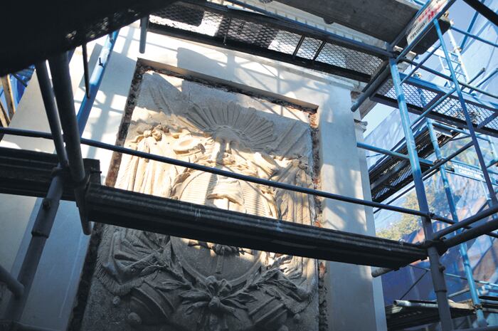 Los escudos, sin las molduras mal hechas de reemplazo y actualmente ventilando las humedades ascendentes.