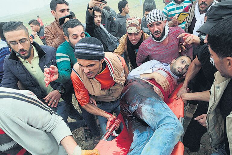 Manifestantes palestinos transportaban el cuerpo sin vida de Mohammed Muheisen ayer en Gaza.