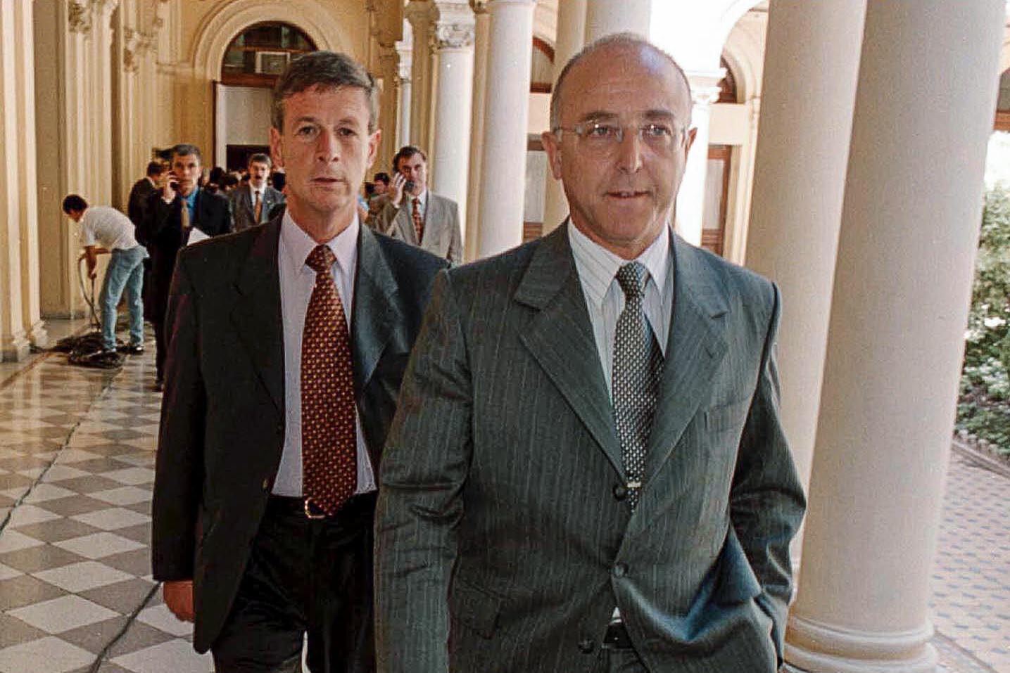 Rubén Santos y Enrique Mathov caminan por Casa Rosada durante el gobierno de De la Rúa.
