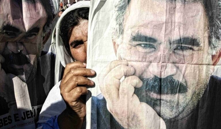 Una seguidora de Öcalan muestra una imagen del líder turco. De Turquía a Palermo, según un informe que citó Clarín.