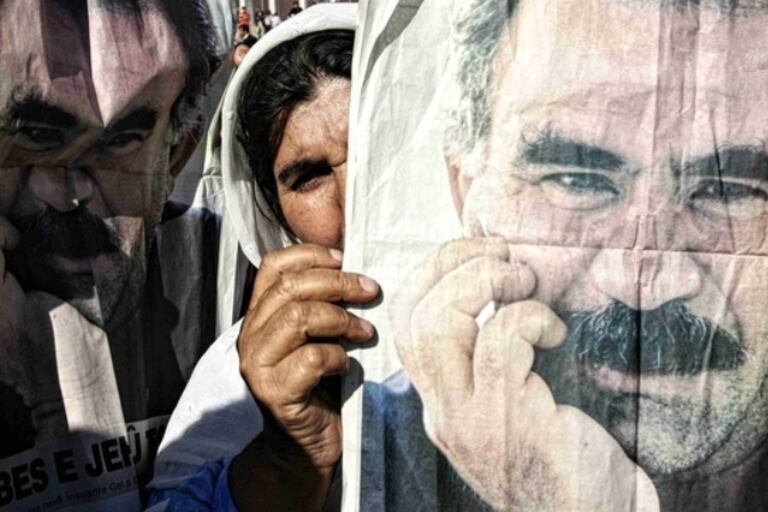 Una seguidora de Öcalan muestra una imagen del líder turco. De Turquía a Palermo, según un informe que citó Clarín.