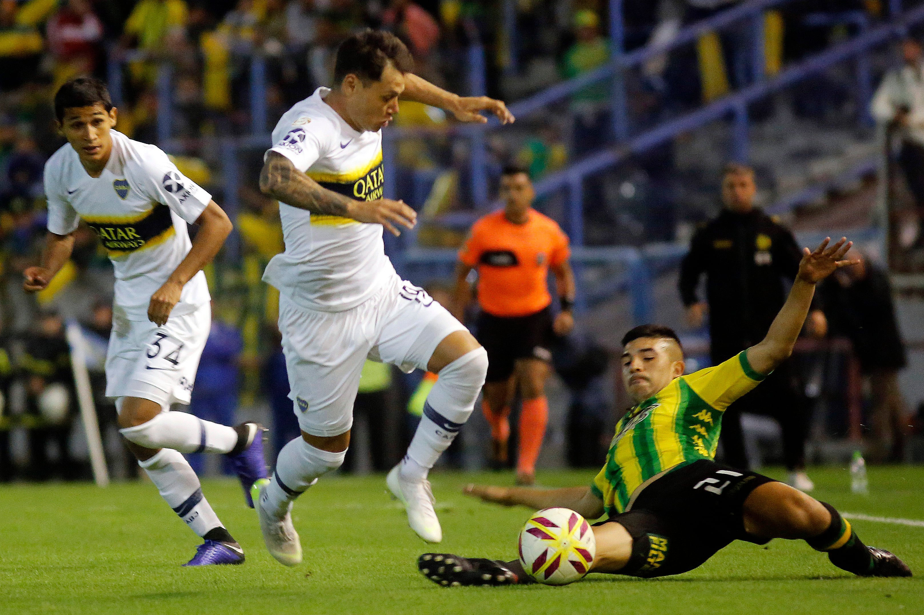 Iníguez va al piso para frenar el avance de Zárate, autor del tanto de Boca en el Minella.