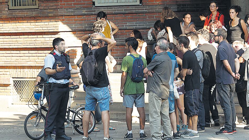 Vecinos ocupando la Escola Collaso i Gil conversan con un Mosso d’Esquadra horas antes del referéndum.