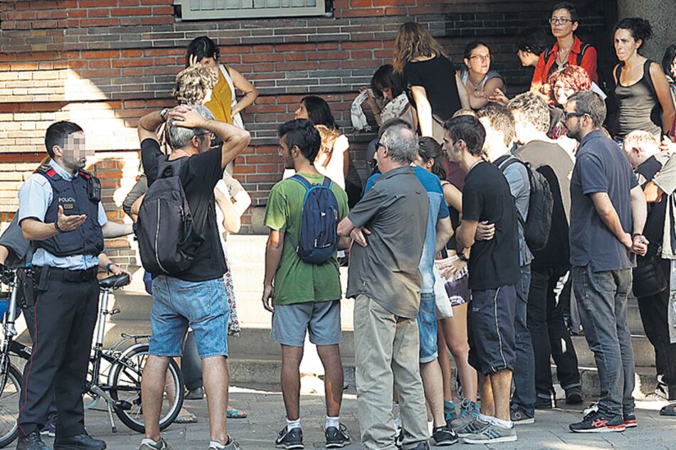 Vecinos ocupando la Escola Collaso i Gil conversan con un Mosso d’Esquadra horas antes del referéndum.