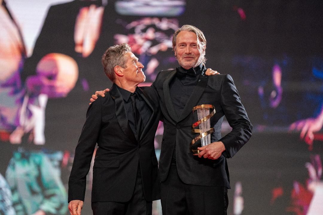 El danés Mads Mikkelsen recibió en la inauguración un premio a la trayectoria de manos de su colega Willem Dafoe.