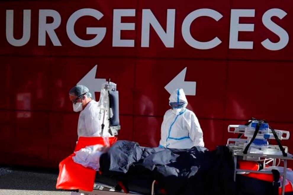 Dos camilleros ingresan a un pacientes a cuidados intensivos en Francia.